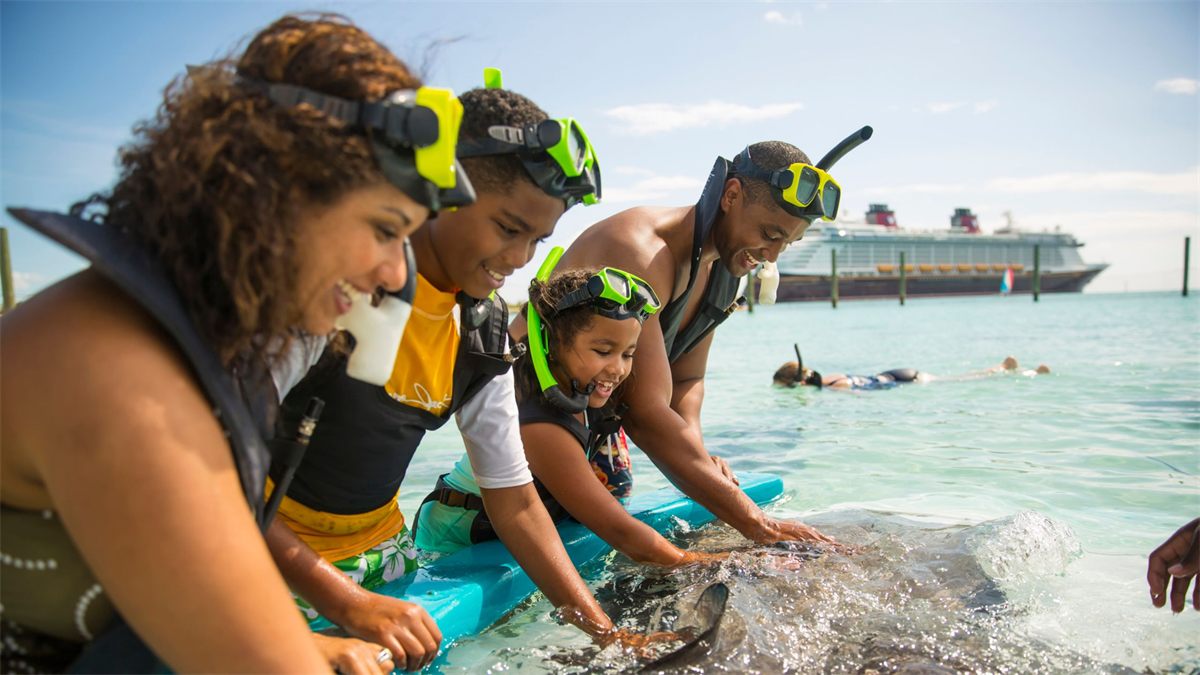A family meets a stingray at Disney Castaway Cay, the line’s private island